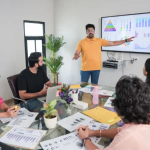 Team meeting with graphs on screen presentation.